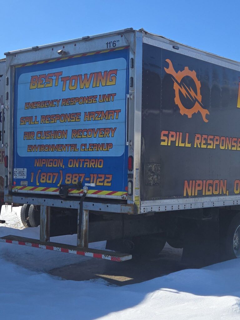 Back of Best Towing truck showing emergency services, parked in snow.
